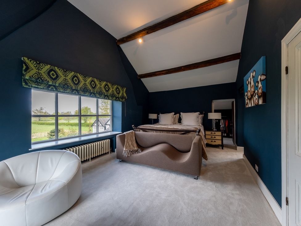 A bedroom with a bed and a chaise lounge at Hall O'Coole near Wrenbury