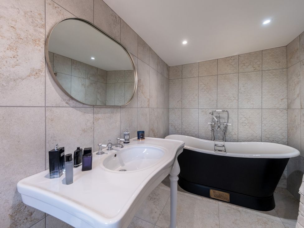 A bathroom with a bathtub and wash basin at Hall O'Coole in Broomhall nearn Wrenbury