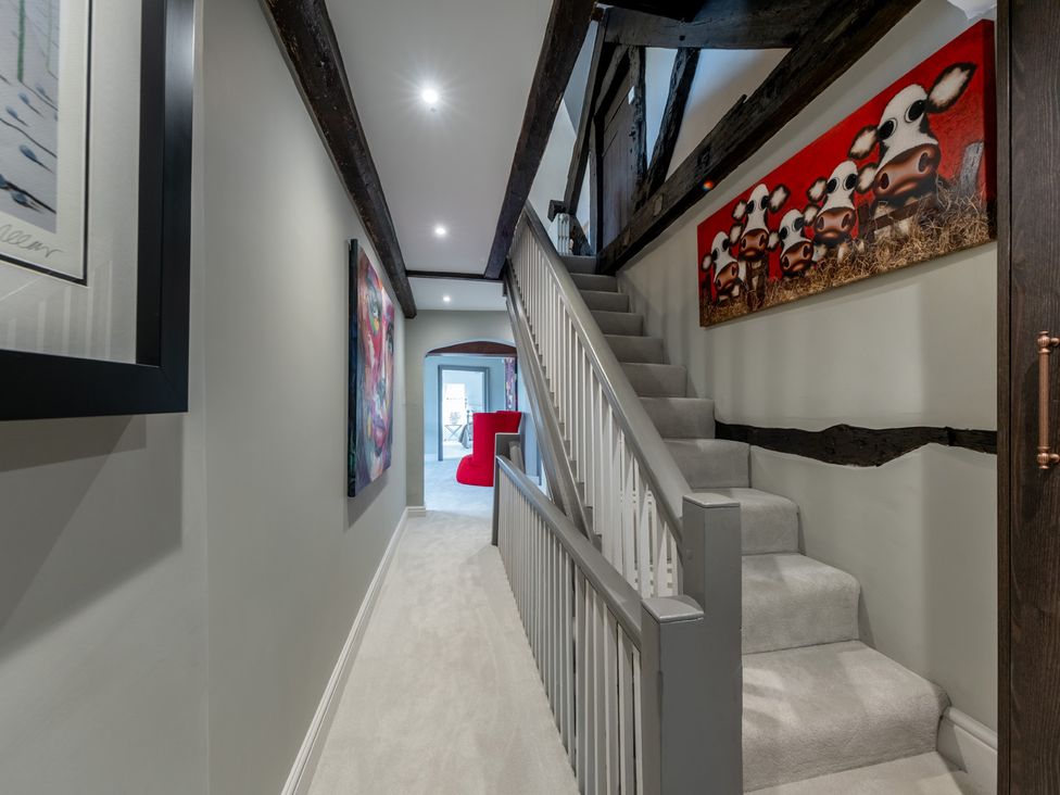 A hallway with a staircase and artwork at Hall O'Coole in Broomhall near Wrenbury