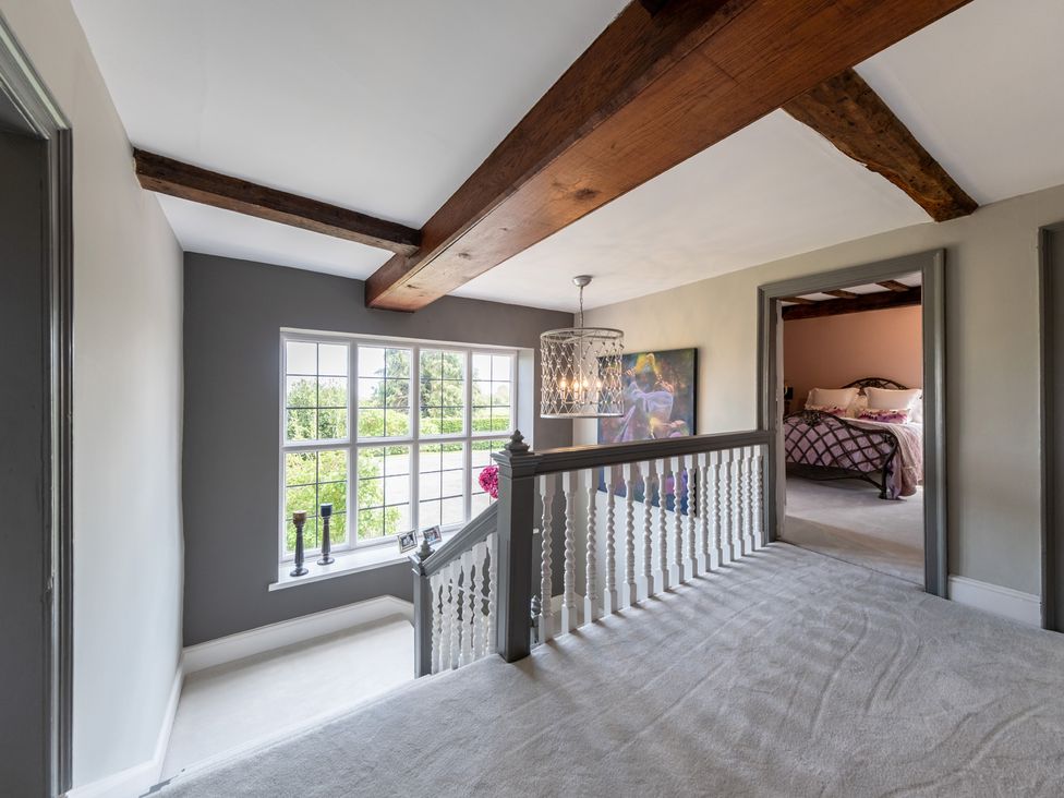 A hallway with a staircase and window at Hall O'Coole in Broomhall nearn Wrenbury