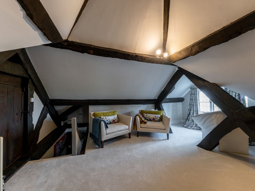 A loft with two chairs and wooden beams at Hall O'Coole in Broomhall nearn Wrenbury