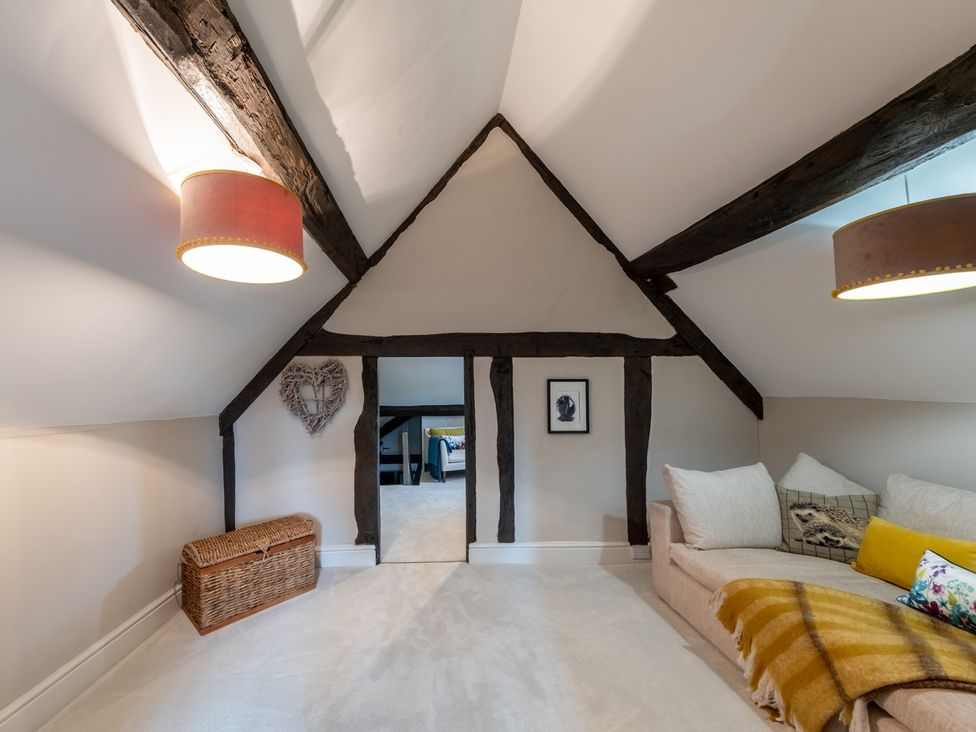 A snug with a sofa and wooden beams at Hall O'Coole in Broomhall nearn Wrenbury
