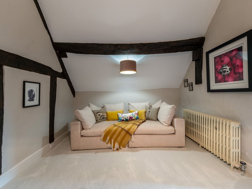 A snug with a sofa and cushions at Hall O'Coole in Broomhall nearn Wrenbury