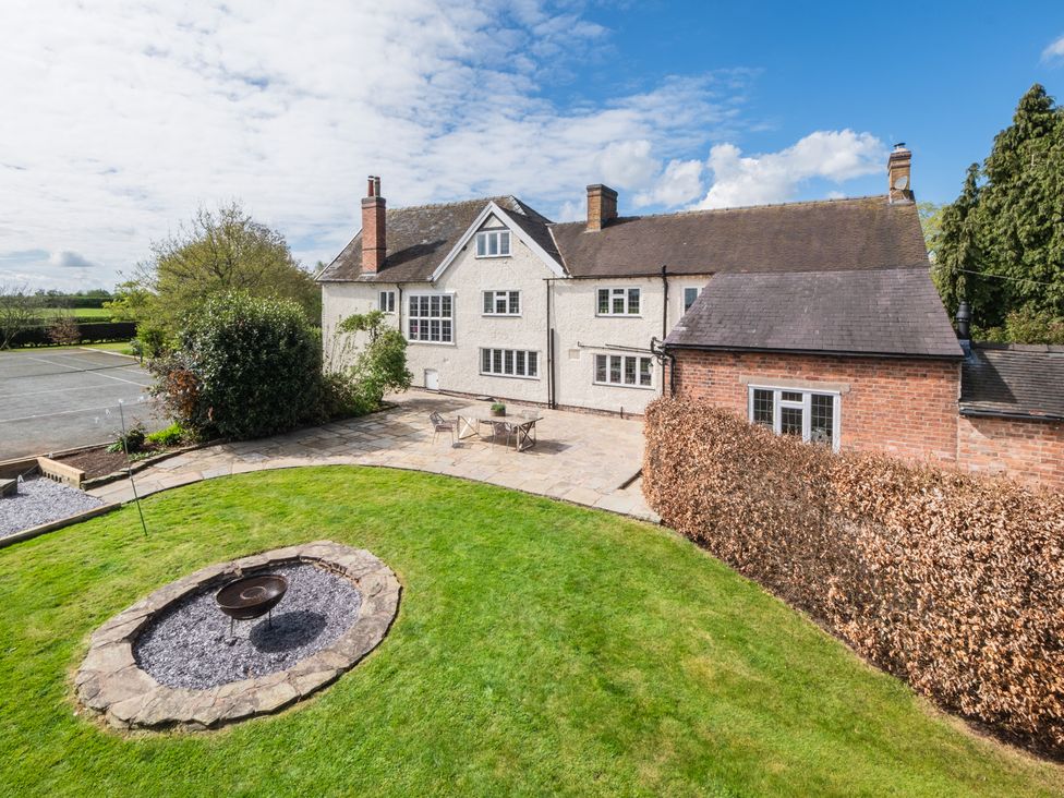 A garden with a fire pit and patio area at Hall O'Coole in Broomhall near Wrenbury