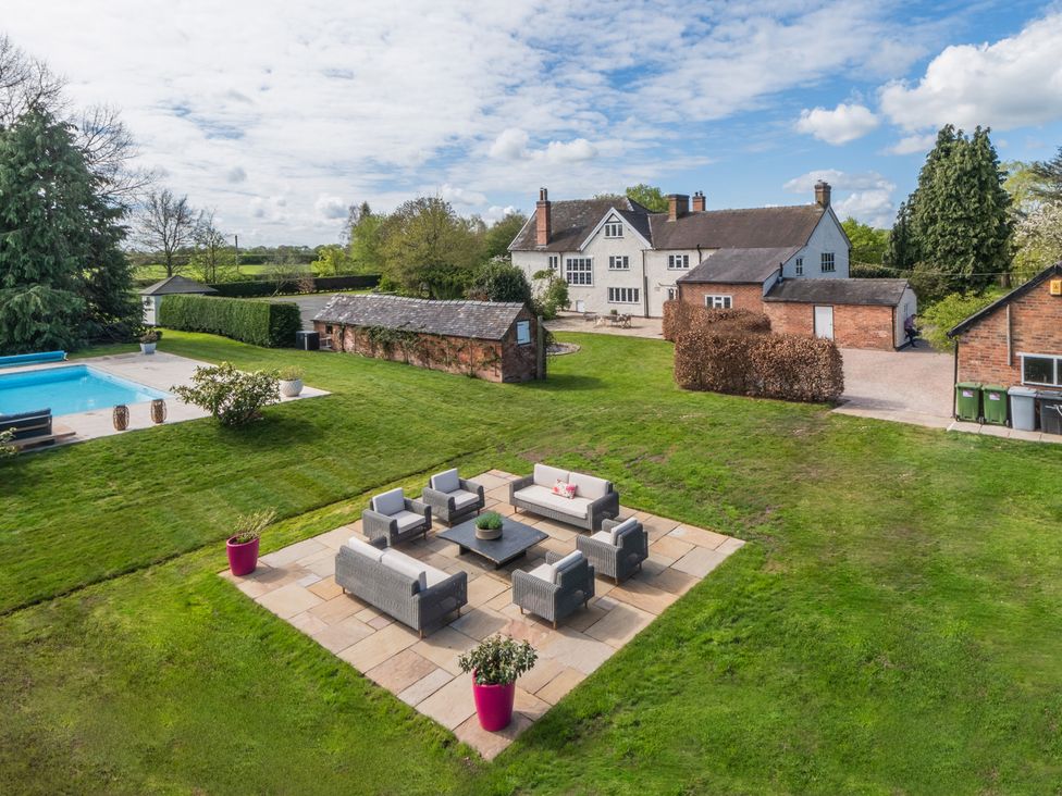 An outdoor seating area near a swimming pool at Hall O'Coole in Broomhall nearn Wrenbury