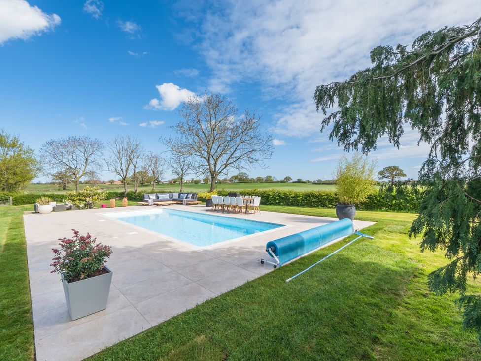 An outdoor space with a swimming pool and seating area at Hall O'Coole in Broomhall nearn Wrenbury