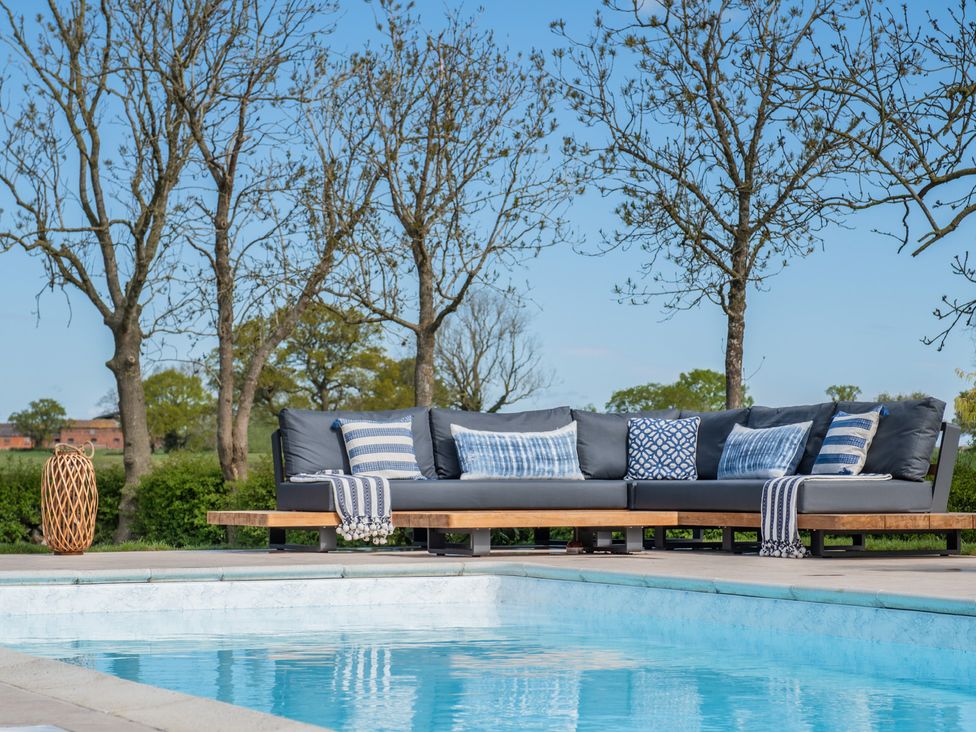 An outdoor area with a sofa and pool at Hall O'Coole Broomhall nearn Wrenbury