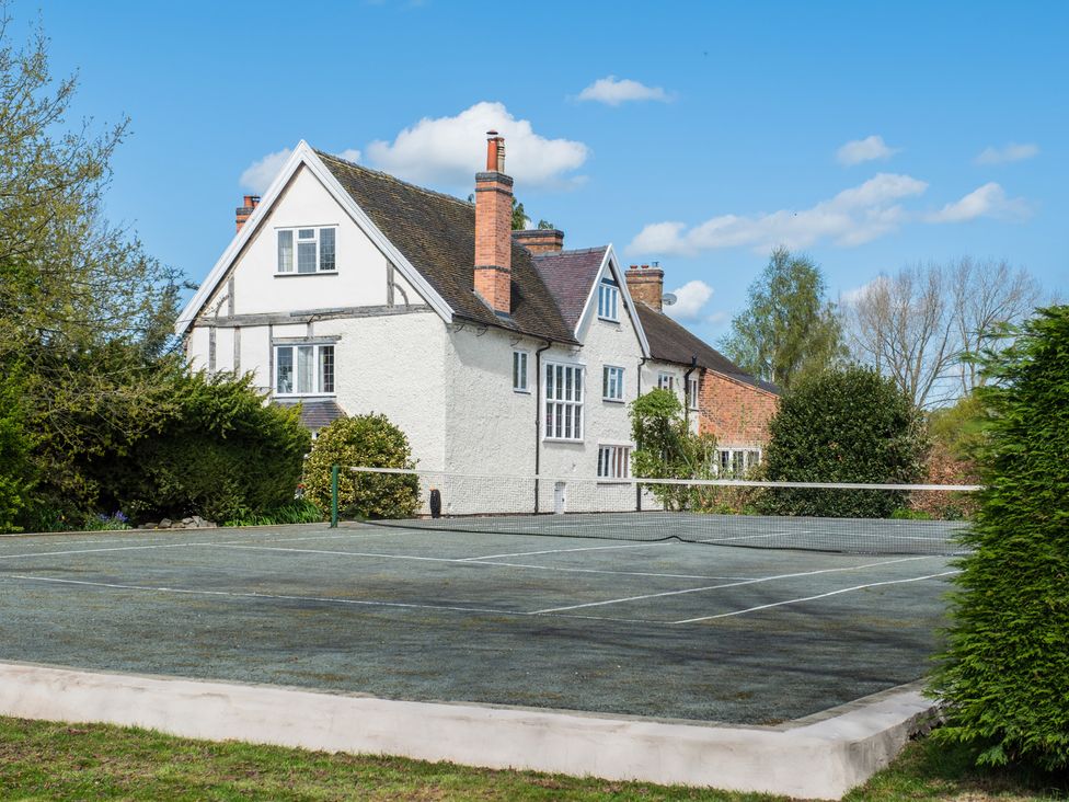 A house with a tennis court in the outdoor area at Hall O'Coole in Broomhall near Wrenbury