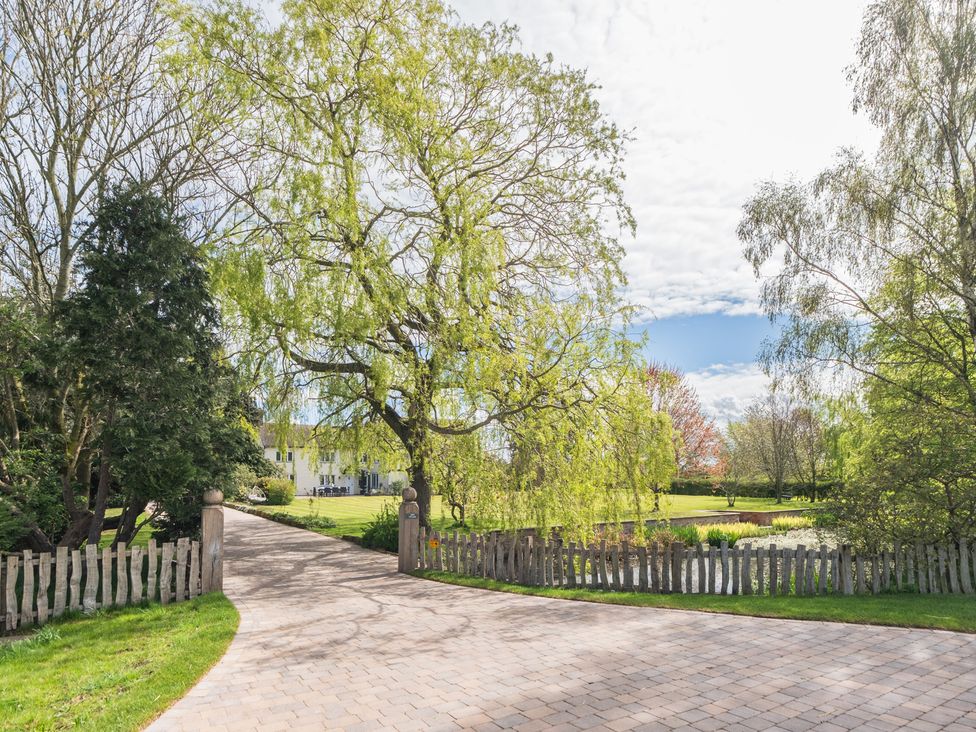 A pathway leading to a building with trees and a pond at Hall O'Coole in Broomhall nearn Wrenbury