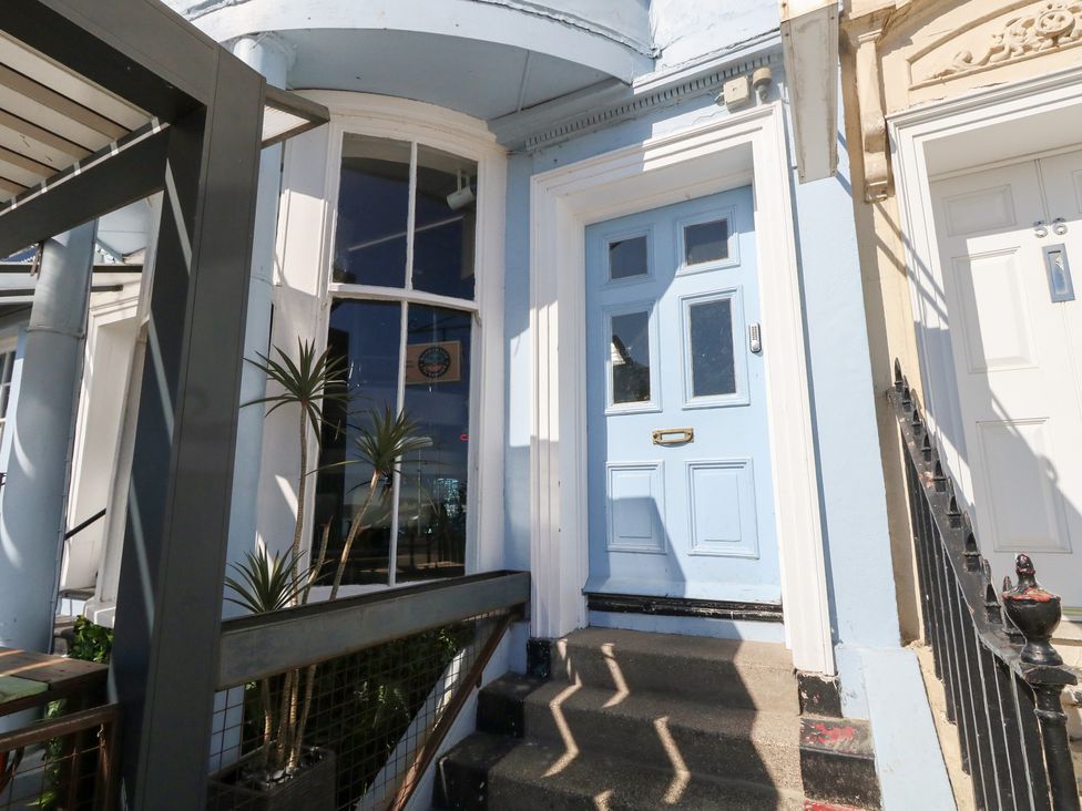 An entrance with a blue front door and steps at The Beach Condo in Weymouth
