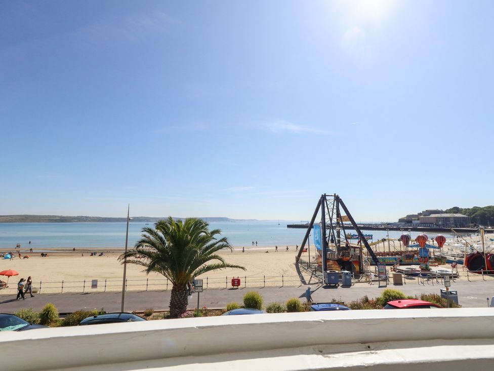 A beach view with a playground in the foreground at The Beach Condo in Weymouth