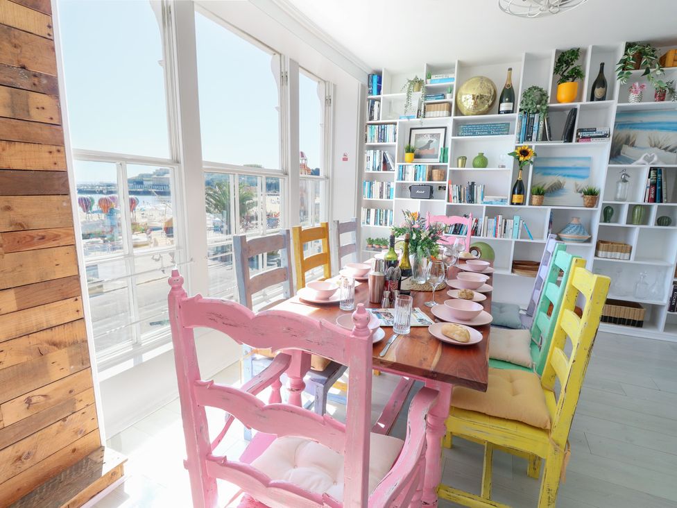 A dining room with a table set for meals at The Beach Condo in Weymouth