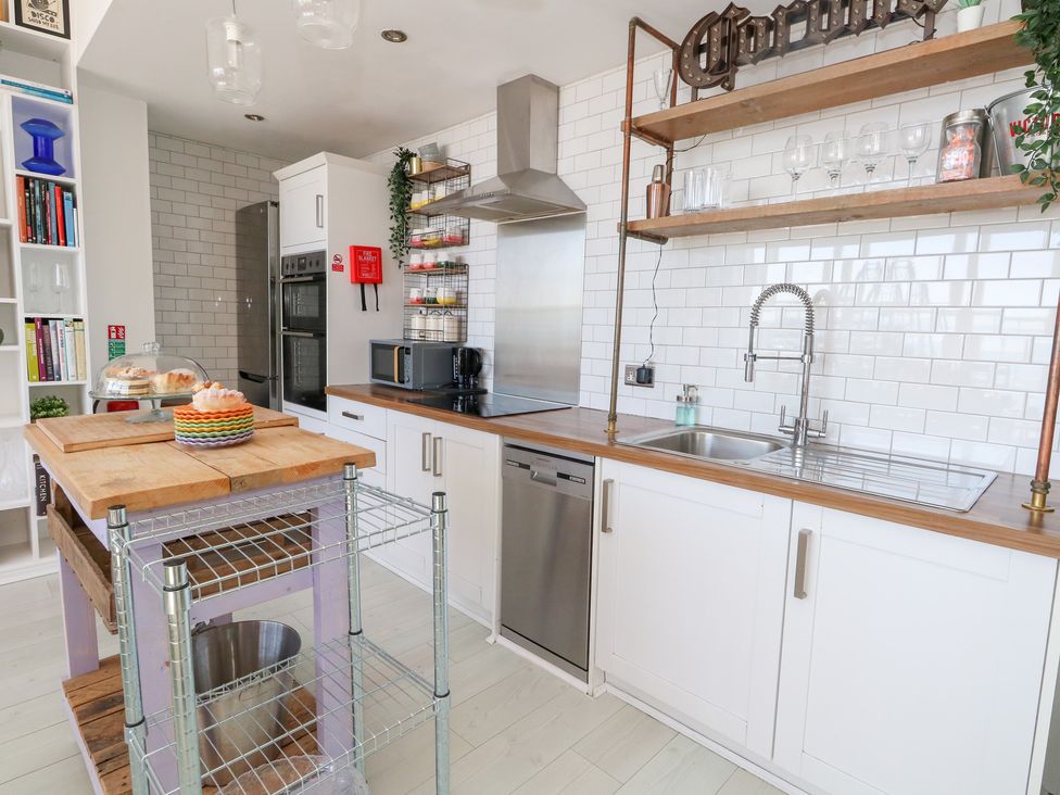 A kitchen with a sink, oven, and kitchen island at The Beach Condo in Weymouth