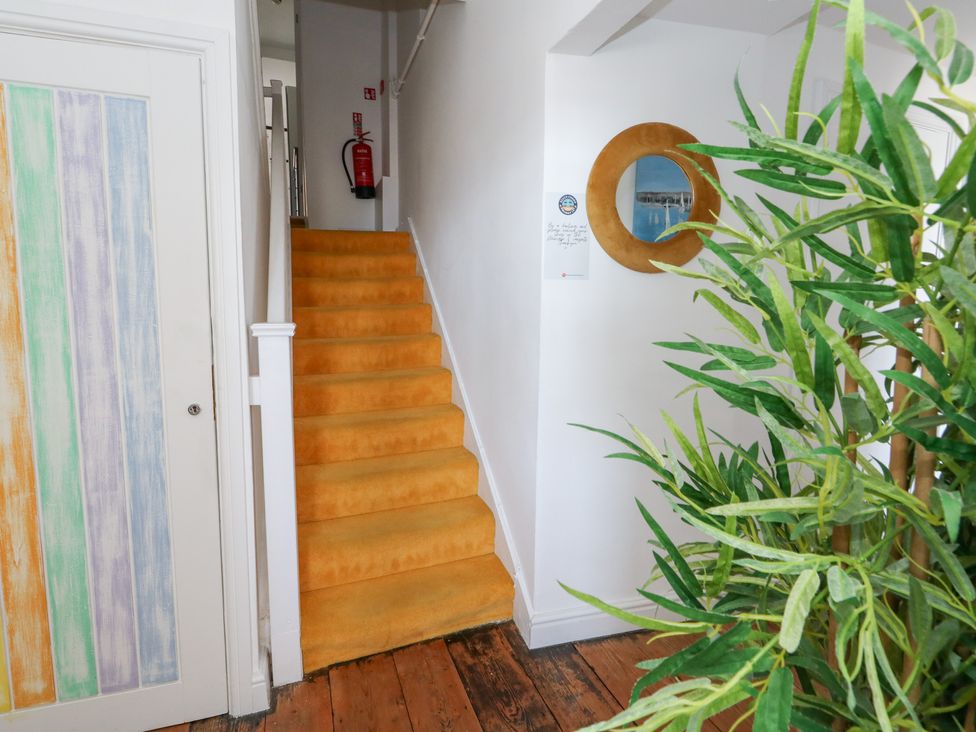 A hallway with a staircase and door at The Beach Condo in Weymouth