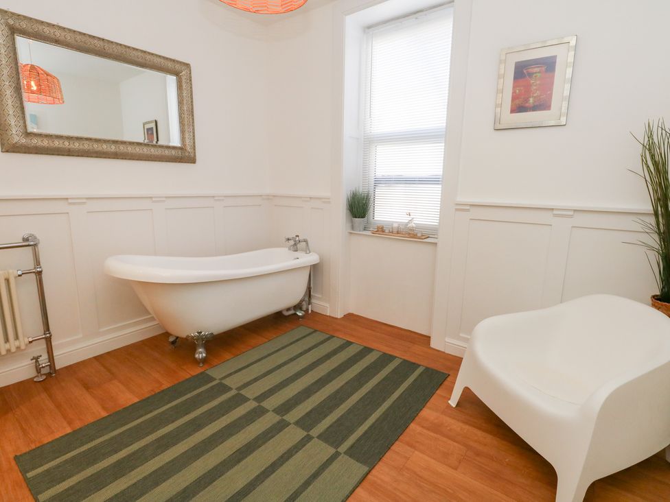 A bathroom with a bathtub and a plant at The Beach Condo in Weymouth