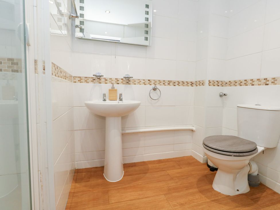 A bathroom with a sink, toilet, and shower at The Beach Condo in Weymouth