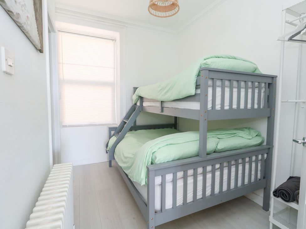 A bedroom with a bunk bed and radiator at The Beach Condo in Weymouth