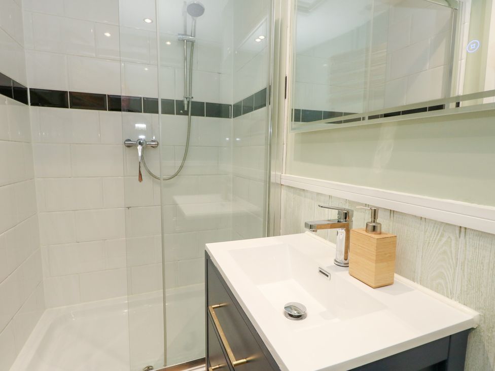 A bathroom featuring a shower and sink at The Beach Condo in Weymouth