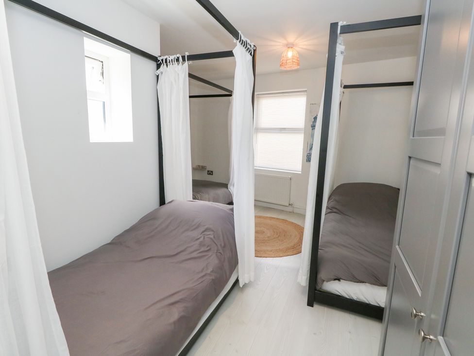 A bedroom with two single beds and a window at The Beach Condo in Weymouth