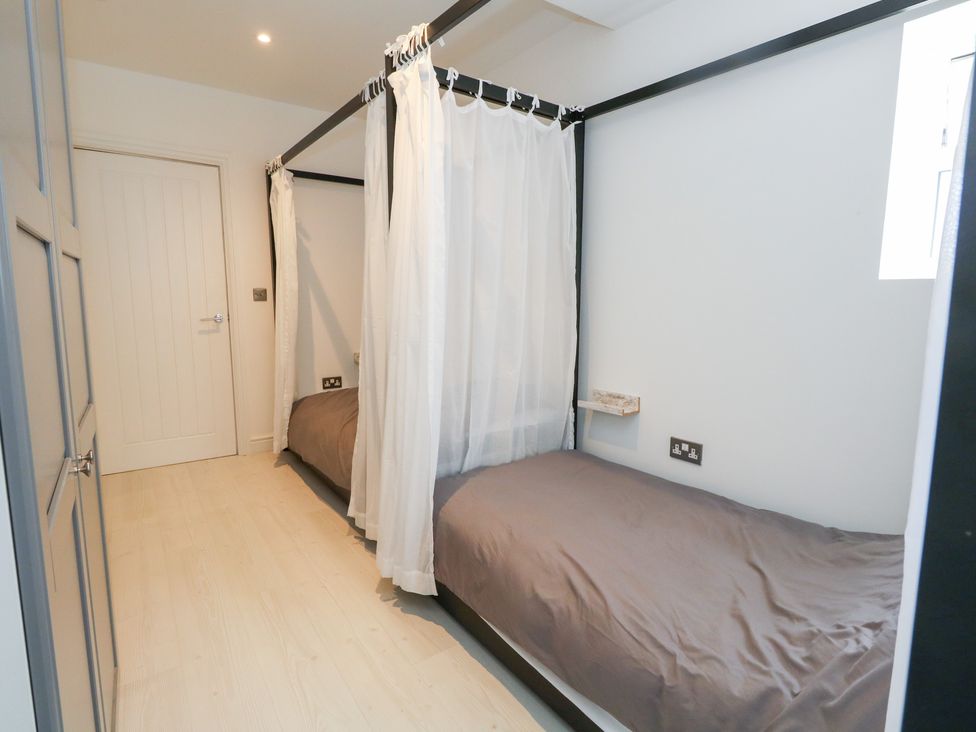 A bedroom with two beds and curtains at The Beach Condo in Weymouth