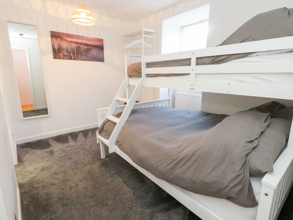 A bedroom with a bunk bed and a mirror at The Beach Condo in Weymouth