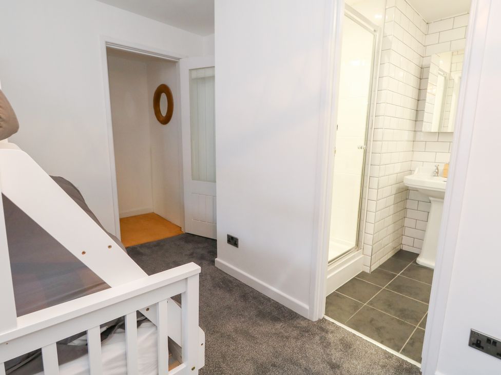 A bathroom with a shower cubicle and a wash basin at The Beach Condo in Weymouth