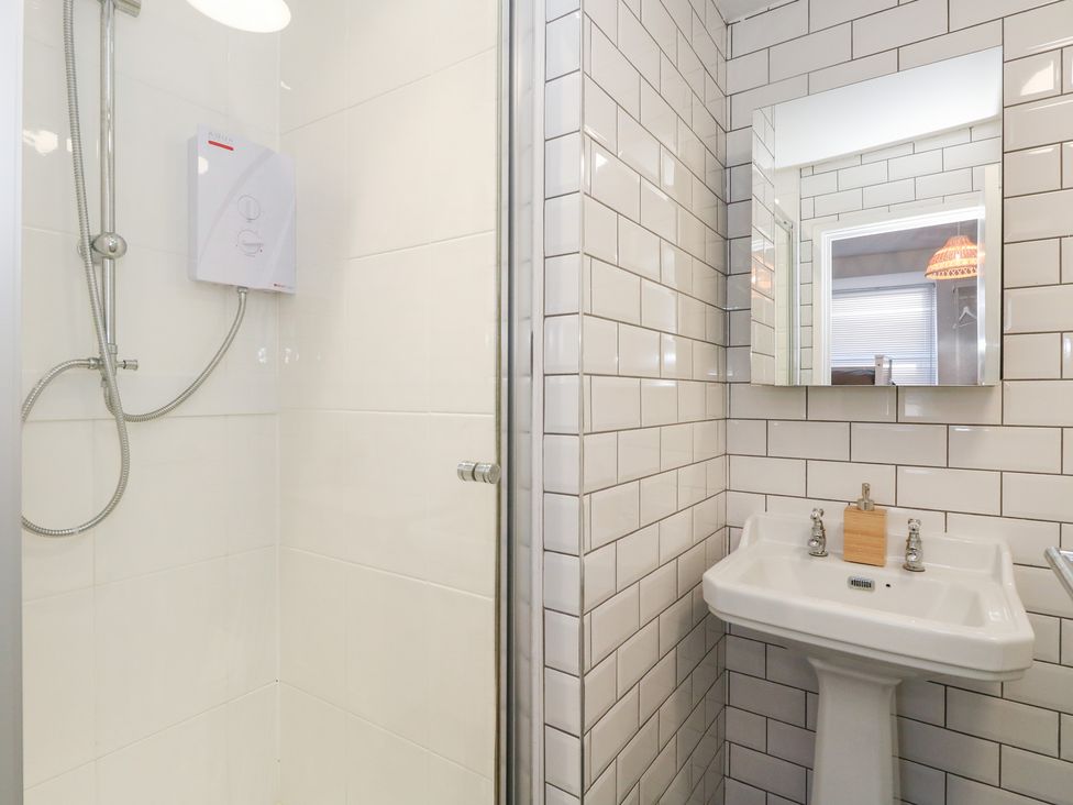 A bathroom with shower and sink at The Beach Condo in Weymouth
