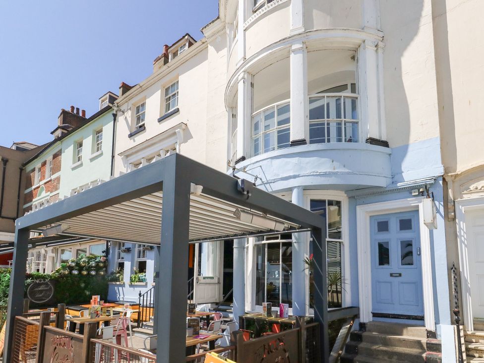 An outdoor seating area in front of a building at The Beach Condo in Weymouth