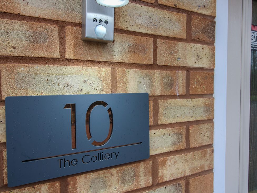 A house number sign on a brick wall at 10 The Colliery in Telford