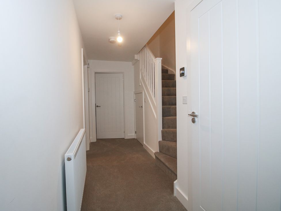 A hallway with stairs and a door at 10 The Colliery Telford
