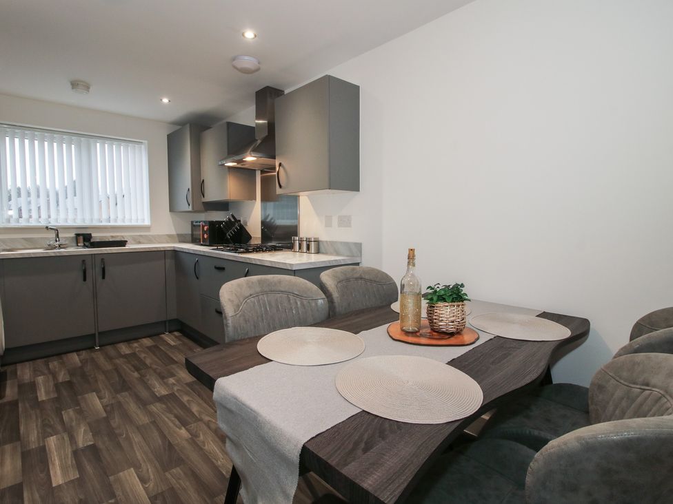 A kitchen with a dining table and chairs at 10 The Colliery in Telford