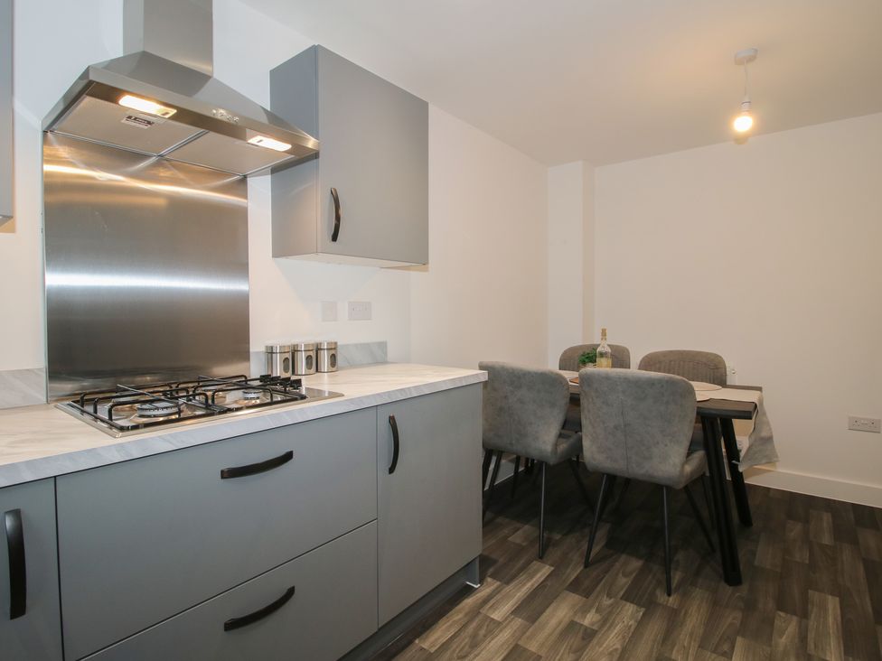 A kitchen with a gas stove and dining table at 10 The Colliery Telford