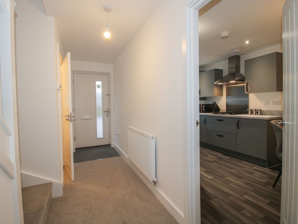 A hallway with a front door and view into the kitchen at 10 The Colliery Telford