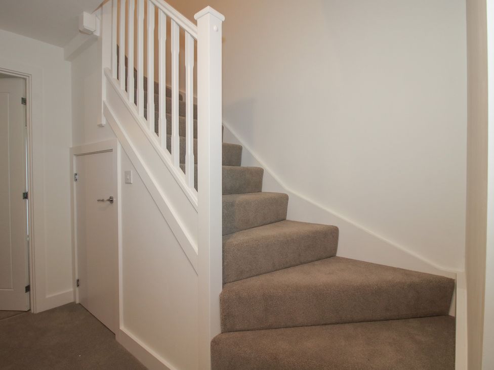 A hallway with stairs and a door at 10 The Colliery Telford