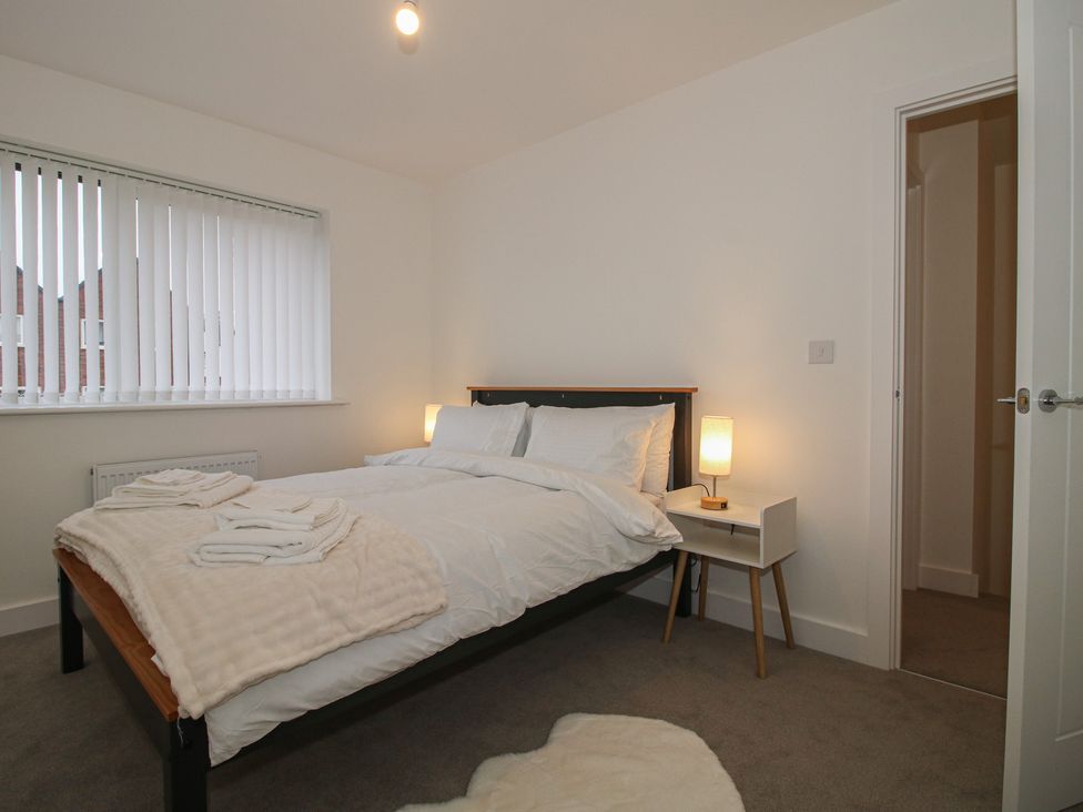 A bedroom with a bed and bedside table at 10 The Colliery in Telford