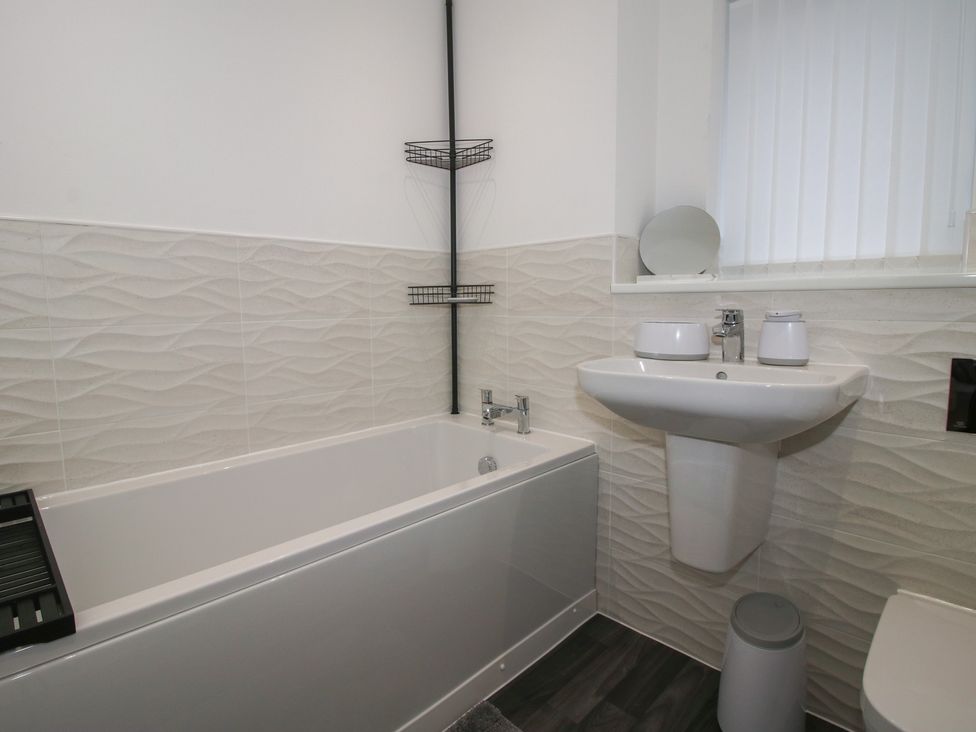 A bathroom with a bath, sink, and toilet at 10 The Colliery in Telford