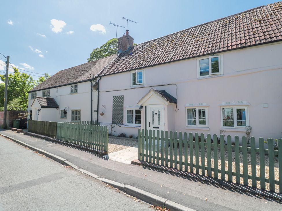 A house with a picket fence and pathway at Old Farm Cottage in Warminster