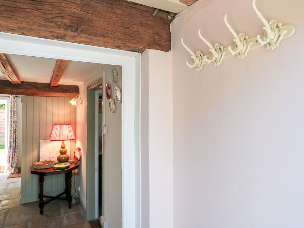 An entryway with a lamp and table at Old Farm Cottage in Warminster