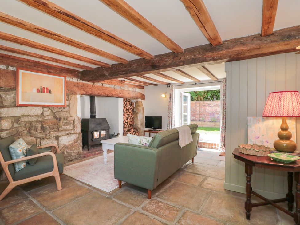 A living room with a fireplace and sofa at Old Farm Cottage Warminster