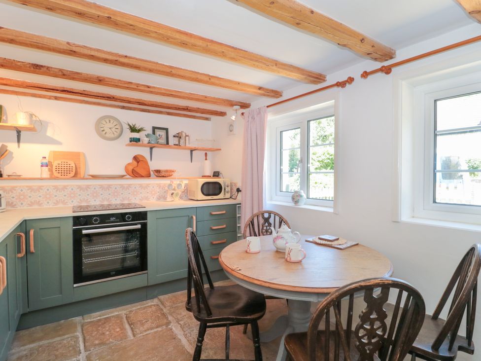 A kitchen with an oven and a table at Old Farm Cottage in Warminster