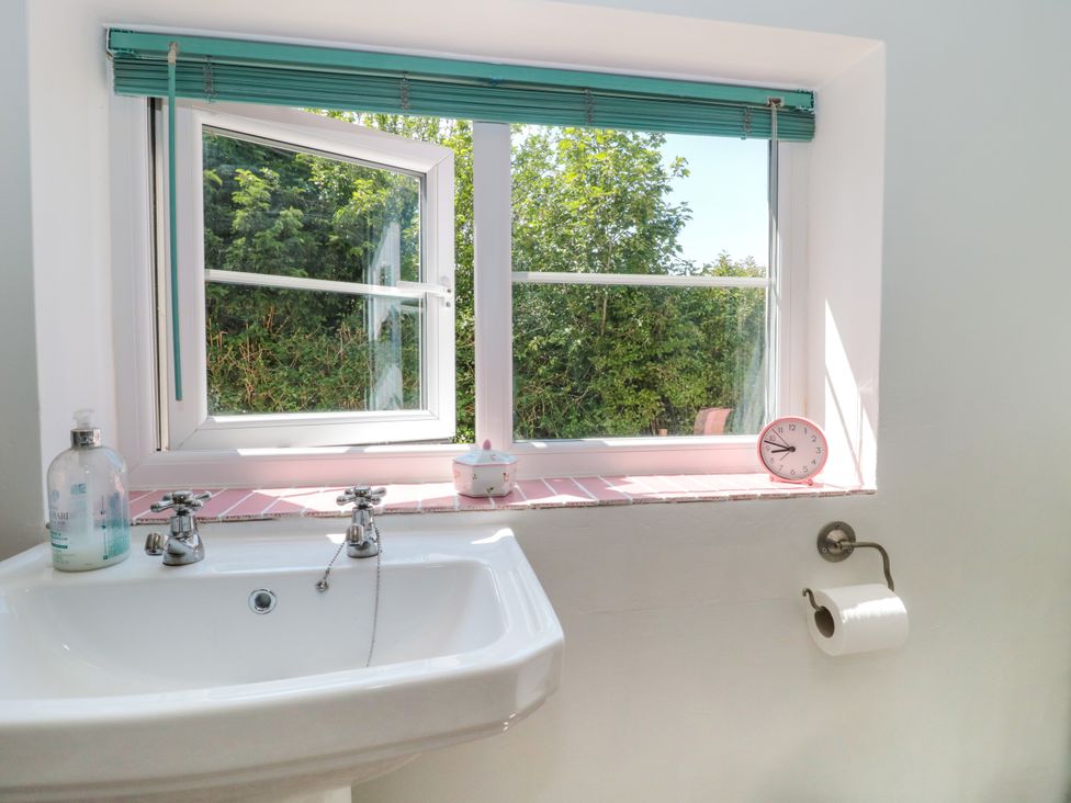 A bathroom with a sink and window at Old Farm Cottage in Warminster