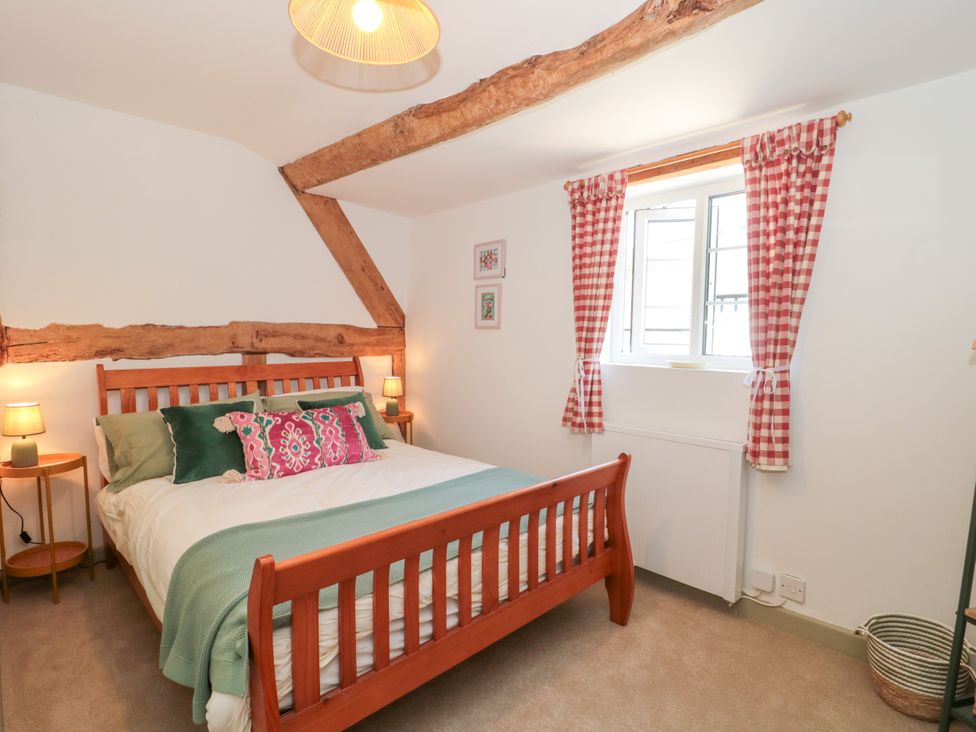 A bedroom with a bed and curtains at Old Farm Cottage in Warminster