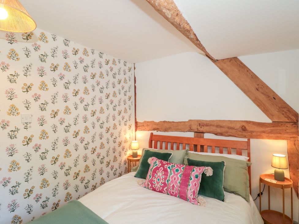 A bedroom with a bed and two lamps at Old Farm Cottage in Warminster