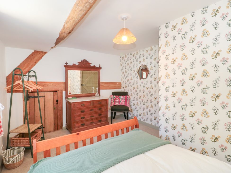 A bedroom with a bed and a dresser at Old Farm Cottage in Warminster