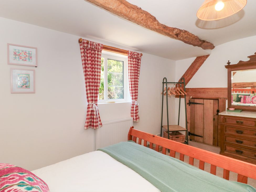 A bedroom with a bed and wardrobe at Old Farm Cottage in Warminster