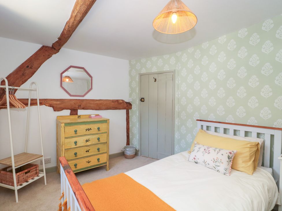 A bedroom with a bed and chest of drawers at Old Farm Cottage in Warminster
