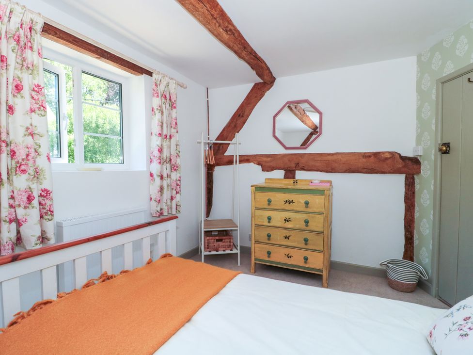 A bedroom with bed and mirror at Old Farm Cottage in Warminster