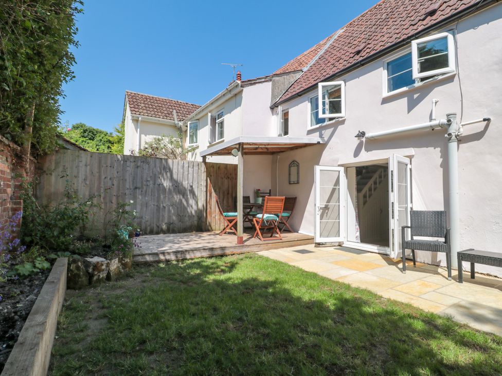 A garden with a table and chairs at Old Farm Cottage in Warminster