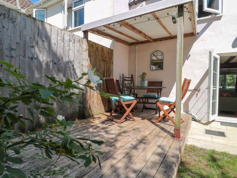 A garden with a table and chairs at Old Farm Cottage in Warminster