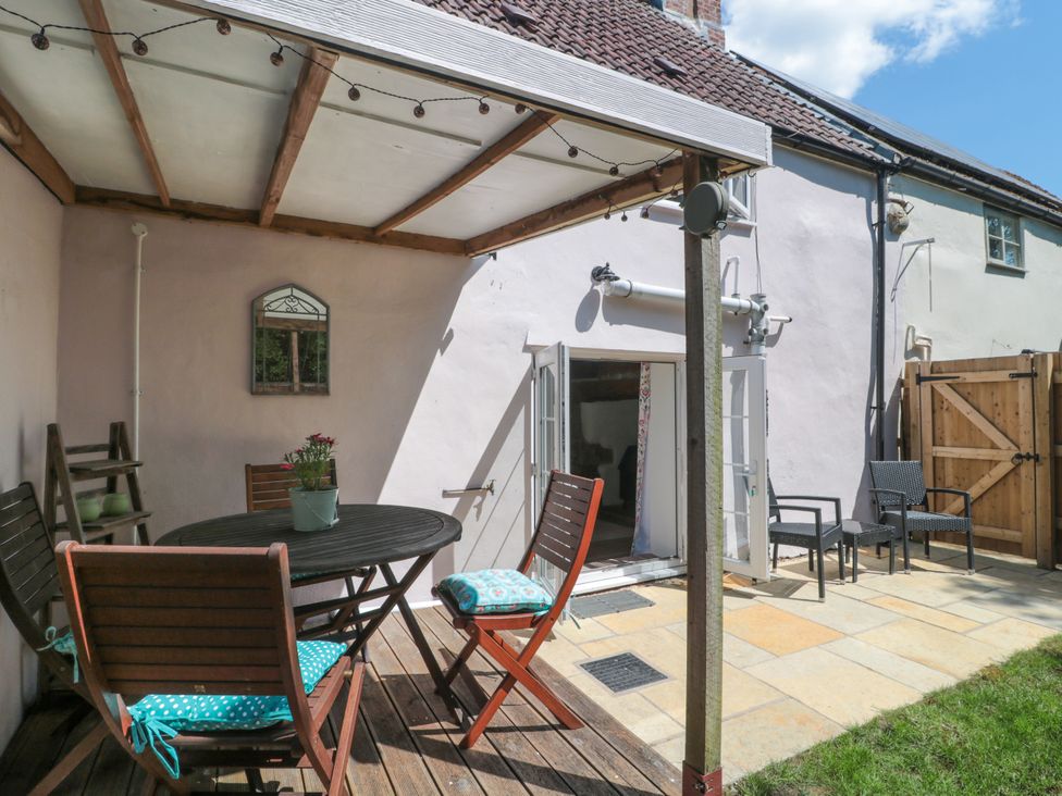 An outdoor patio with a table and chairs at Old Farm Cottage in Warminster